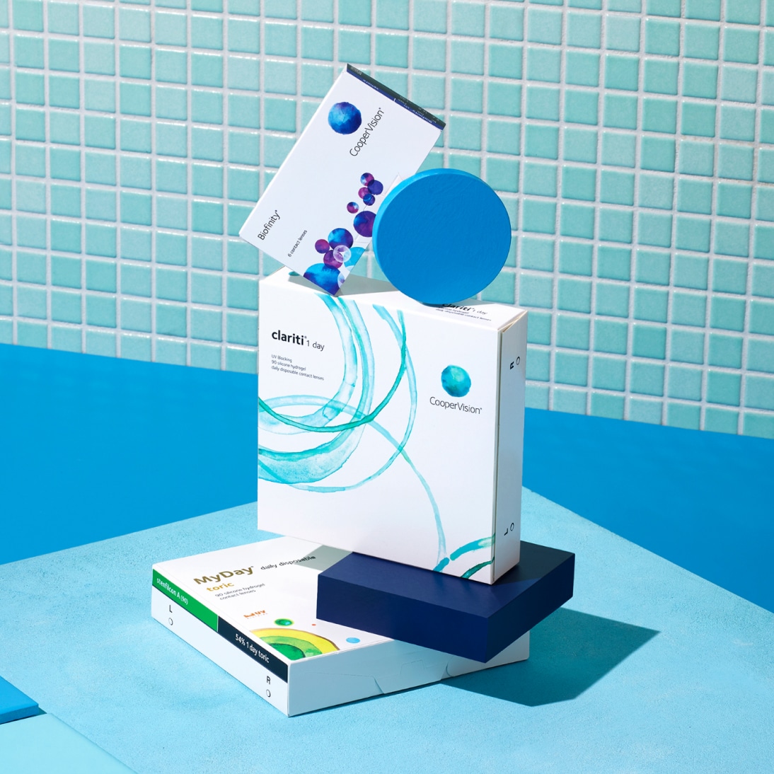 Boxes of contact lenses stacked with blue geometric shapes