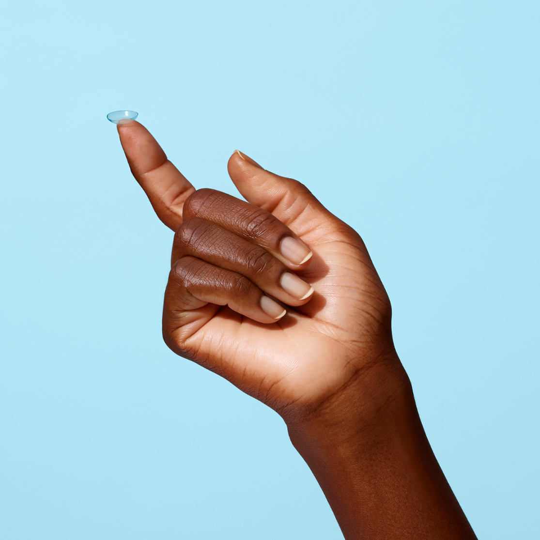Hand balancing a contact lens on its outstretched index finger