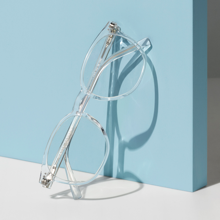 Transparent glasses frames leaning against blue surface
