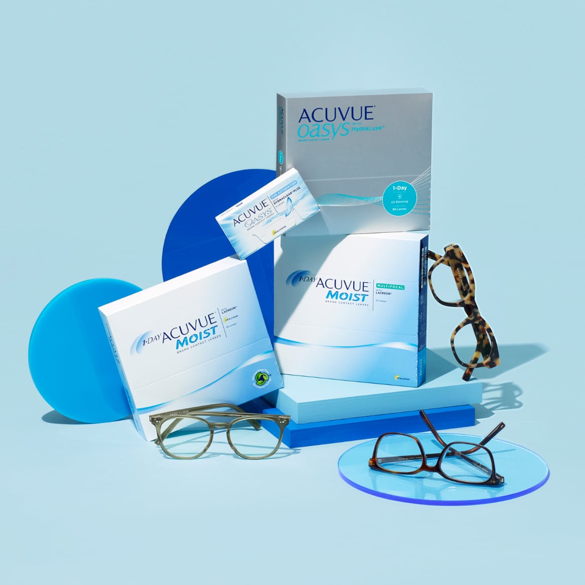 Pairs of glasses pictured with several boxes of contacts