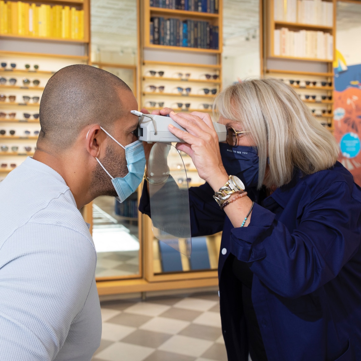 An eye doctor measuring PD with a pupillometer