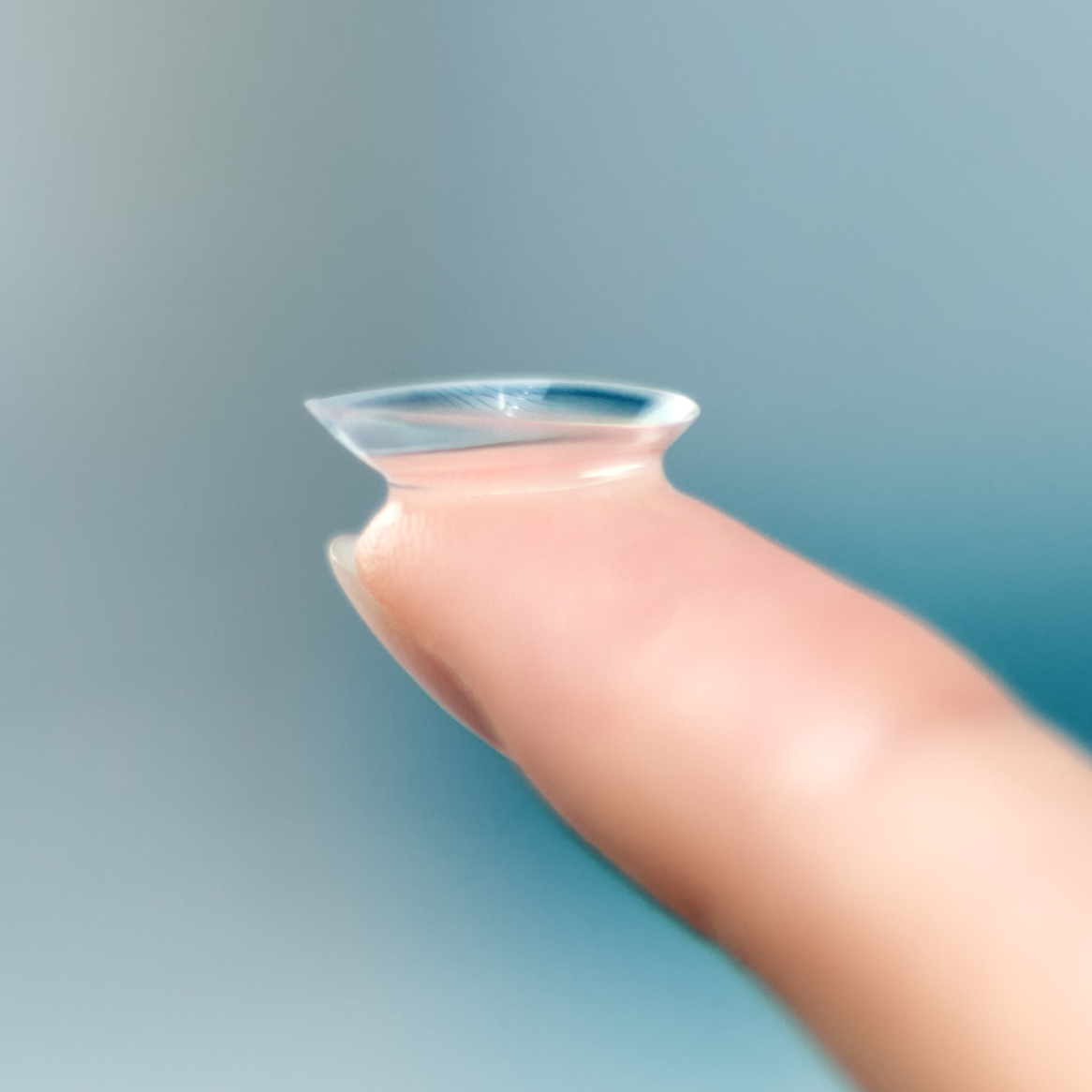 Close-up image of a contact lens on a person's fingertip