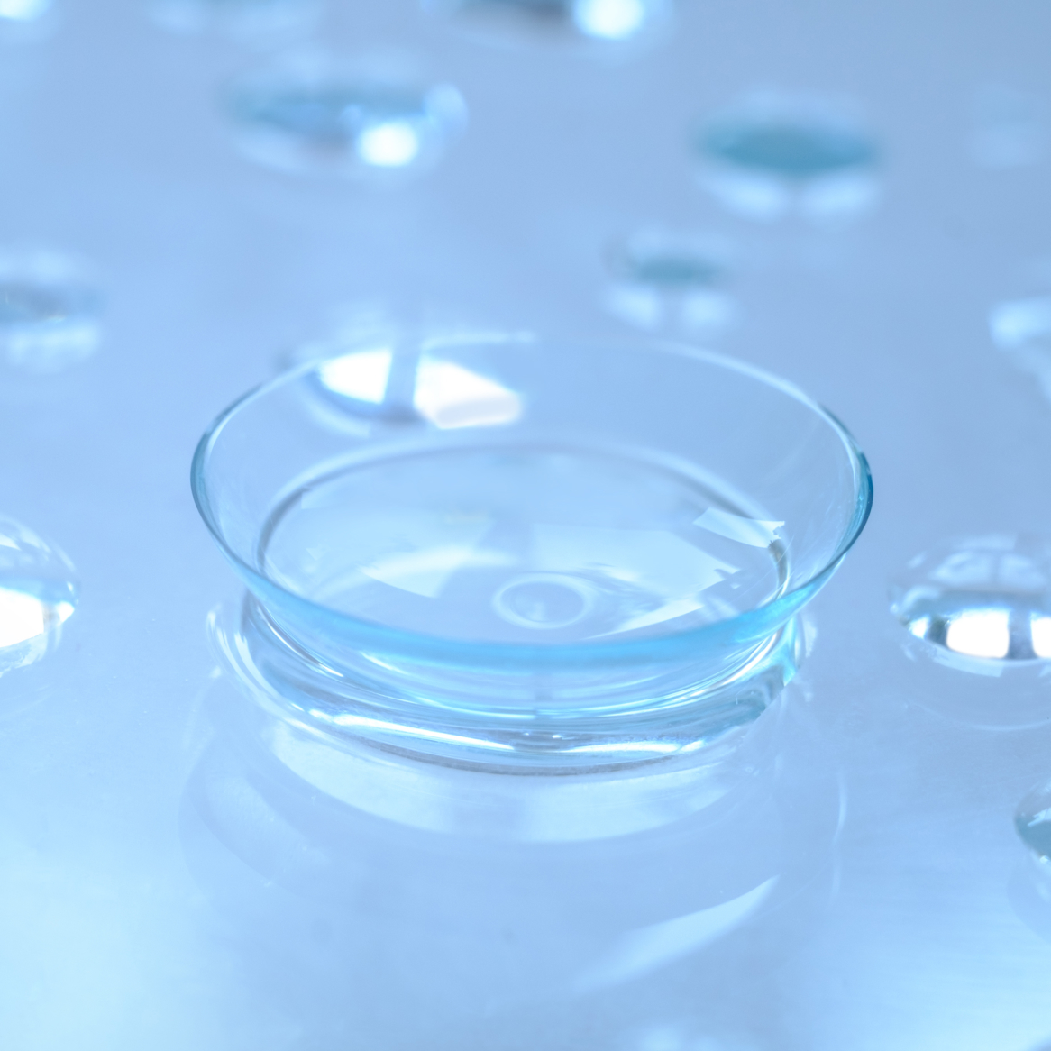 A wet contact lens surrounded by drops of water