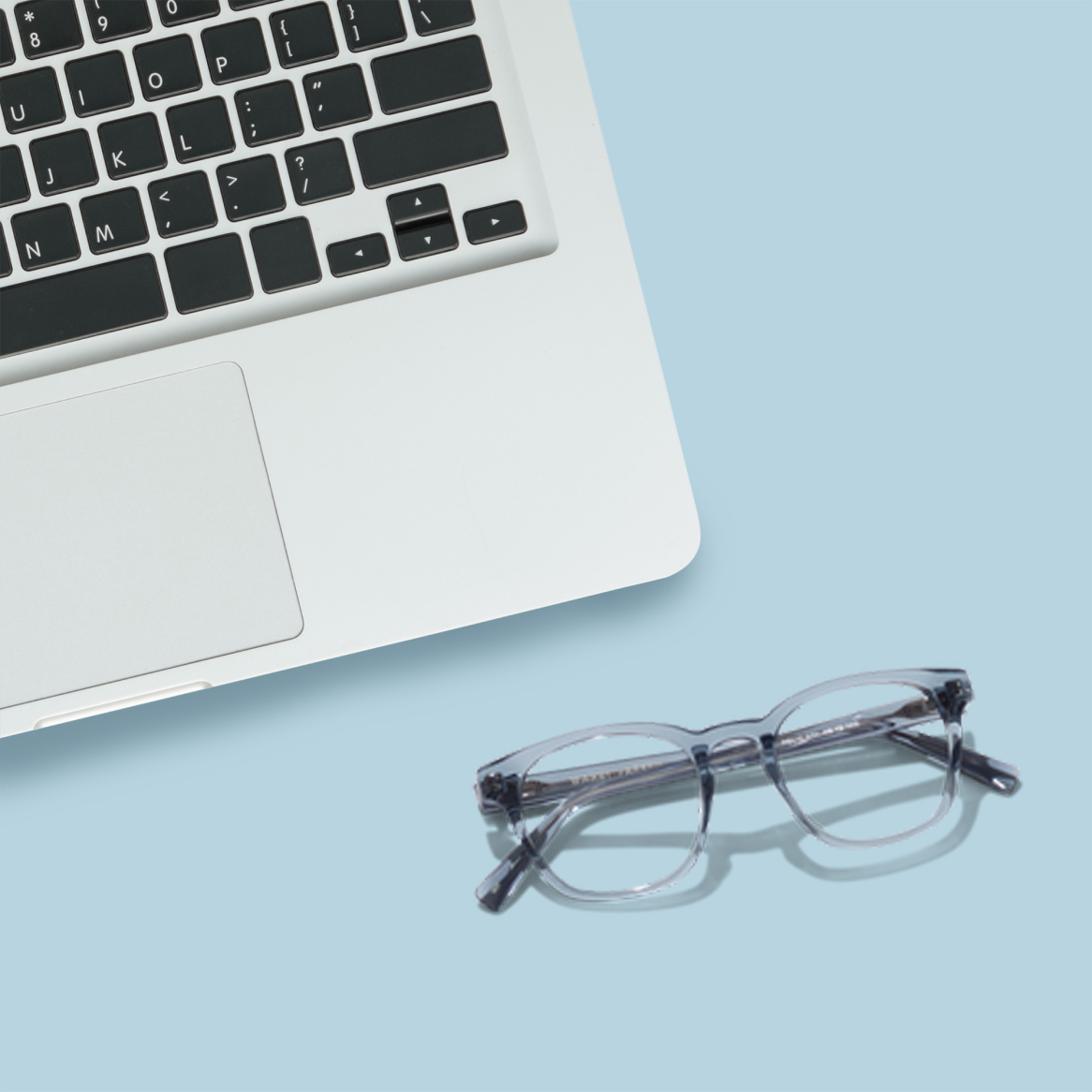 A pair of computer glasses next to a laptop