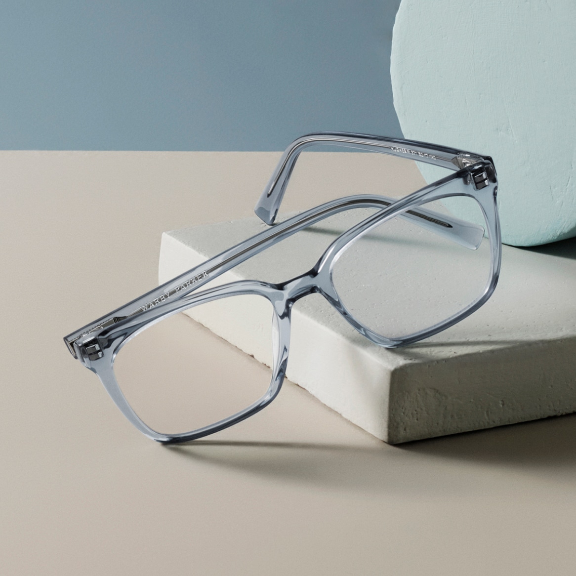 A pair of eyeglasses on a grey block